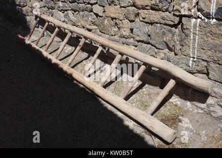 Vintage vecchia scala di legno in diagonale si trova vicino al muro della casa di pietra, il design degli interni della parete. Foto Stock