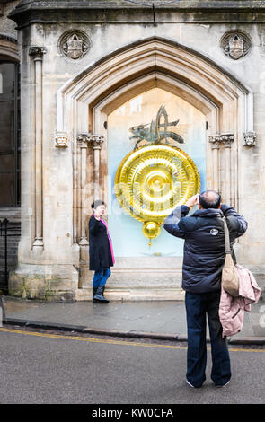 I turisti di fronte al il clock chronophage disegnato da John Taylor presso il Corpus Christi College, Università di Cambridge, Inghilterra. Foto Stock