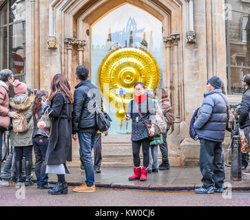 I turisti di fronte al il clock chronophage disegnato da John Taylor presso il Corpus Christi College, Università di Cambridge, Inghilterra. Foto Stock