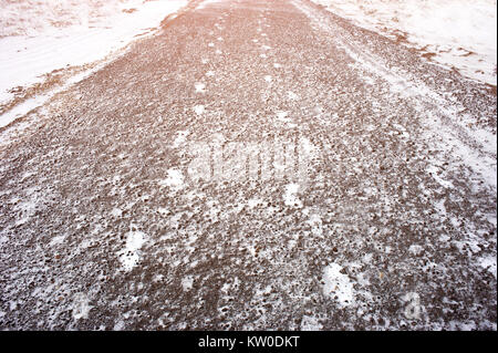 Tracce di neve di due persone su un asfalto percorso in città. Abstract silhouette di una persona di tracce su una strada in inverno Foto Stock