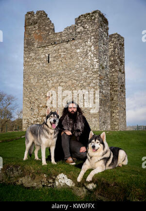 William Mulhall di Direwolf Tours di fronte Audley il castello, in Co Down, con Thor (sinistra) e Odin, due nord cani Inuit egli possiede il quale ha suonato "irewolves' nella hit HBO fantasy fiction, gioco di troni. Foto Stock