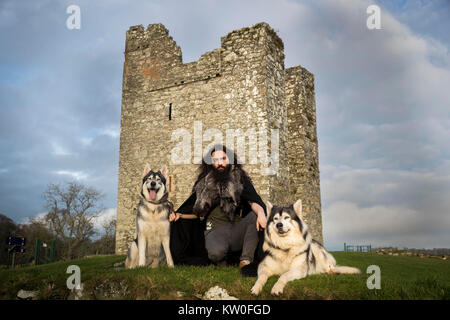 William Mulhall di Direwolf Tours di fronte Audley il castello, in Co Down, con Thor (sinistra) e Odin, due nord cani Inuit egli possiede il quale ha suonato "irewolves' nella hit HBO fantasy fiction, gioco di troni. Foto Stock