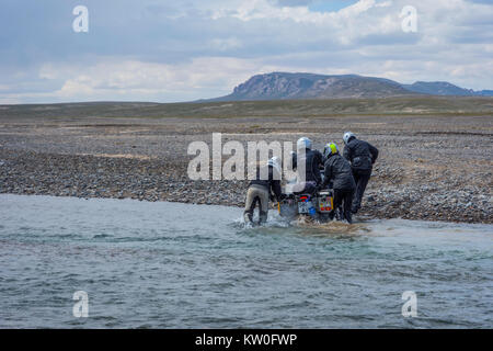 KEL-SUU, Kirghizistan - 13 agosto: gruppo di motociclisti spingendo la moto per attraversare il fiume su off road drive in Tian Shan montagne, Kirghizistan. Agosto Foto Stock