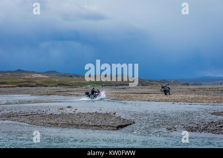 KEL-SUU, Kirghizistan - 13 agosto: gruppo di motociclisti spingendo la moto per attraversare il fiume su off road drive in Tian Shan montagne, Kirghizistan. Agosto Foto Stock