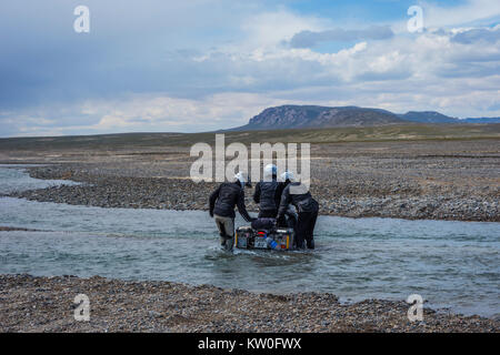 KEL-SUU, Kirghizistan - 13 agosto: gruppo di motociclisti spingendo la moto per attraversare il fiume su off road drive in Tian Shan montagne, Kirghizistan. Agosto Foto Stock