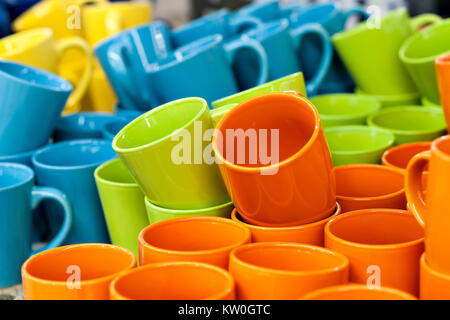 Tazze di ceramica e ciotole di diversi colori nel negozio del contatore, stand in una pila di riga. La vendita e il commercio Foto Stock