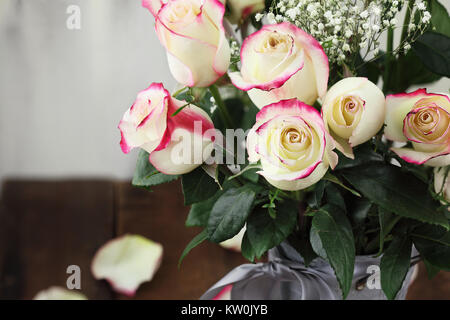 Bel bouquet di rosso e rose bianche con il bimbo di respiro in un metallo stile rustico vaso. Messa a fuoco selettiva su roses in primo piano con estrema dovrà Foto Stock