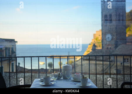 La mattina presto prima colazione continentale a un piccolo hotel a Monterosso Al Mare, le Cinque Terre, con un campanile di una chiesa e il bellissimo mare in vista Foto Stock