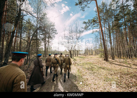 Gruppo di re-enactors vestito come Soviet russo Rosso esercito di soldati di fanteria della II Guerra Mondiale in marcia lungo la strada forestale in estate stagione autunnale. Foto Stock