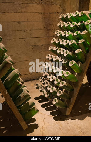 Le bottiglie di vino sono memorizzati invertito in rack in cantina di una cantina di vini in Spagna Foto Stock