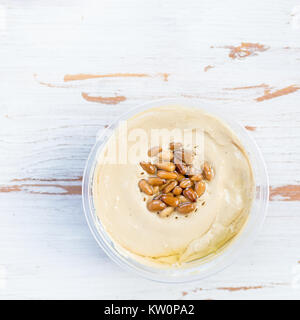 Classic Hummus realizzato da ceci con pinoli sulla parte superiore di legno sfondo rustico, vista dall'alto Foto Stock