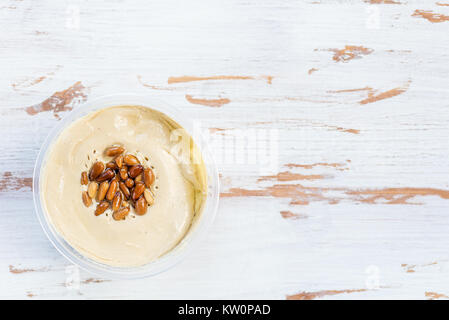 Classic Hummus realizzato da ceci con pinoli sulla parte superiore di legno sfondo rustico, vista dall'alto Foto Stock