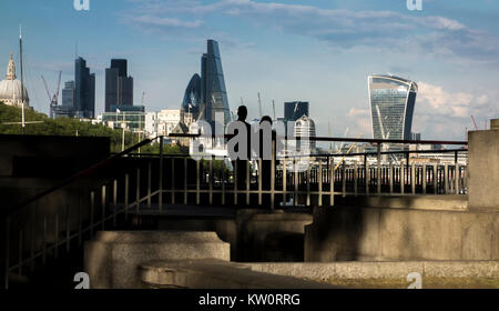 Paio di guardare verso la città di Londra da una piattaforma di osservazione sulla sponda nord del fiume Tamigi sotto il ponte di Waterloo, London, Regno Unito Foto Stock