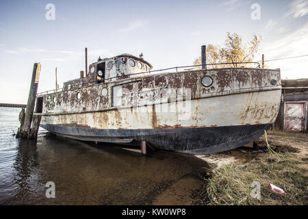 Weathered e indossato la pesca commerciale barca spiaggiata sulle rive del Lago Superiore al punto di coregone in porto la Penisola Superiore del Michigan. Foto Stock