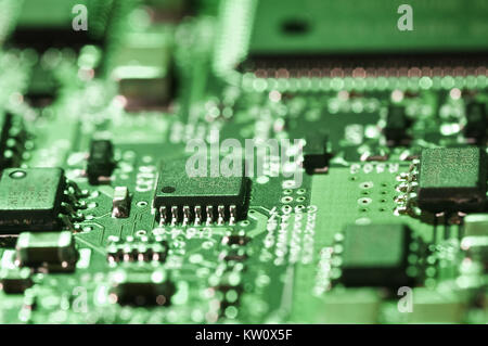 Messa a fuoco selettiva su microchip su una scheda di circuito accesa con luce verde Foto Stock
