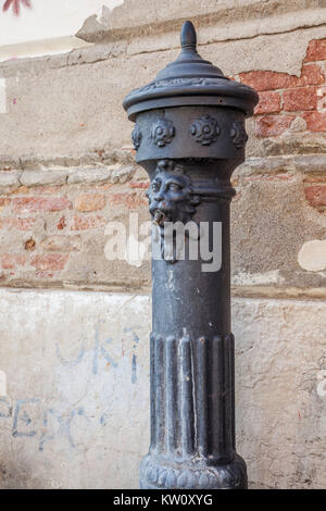 Vista ravvicinata pubblica di un rubinetto di acqua/idrante sulla Terra Saloni, Venezia contro uno sfondo di un reso parzialmente sbriciolare un muro di mattoni Foto Stock