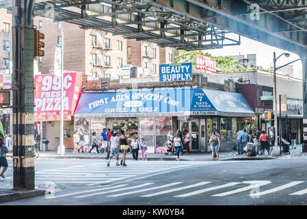 Bronx, Stati Uniti d'America - 11 Giugno 2017: Strada e la strada sotto il sottopassaggio ferroviario con ristoranti e negozi con il marciapiede in downtown area Fordham Foto Stock