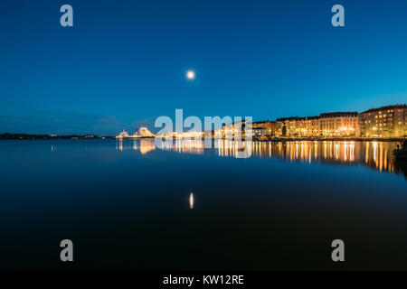 Helsinki, Finlandia. Vista del porto di polizia Merikasarmin Laituri e Laivastokatu Street a sera tarda serata luminarie. Foto Stock