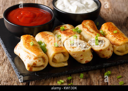 Frittelle panini con pollo, formaggio e funghi close-up e salse sul tavolo orizzontale. Foto Stock