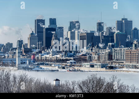 Montreal, CA - 28 dicembre 2017: Lo skyline di Montreal in inverno come ghiaccio nebbia sorge fuori del fiume San Lorenzo Foto Stock