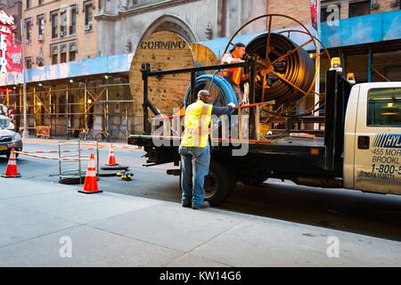 Due lavoratori in alta visibilità gilet lavoro per stabilire comunicazioni ottiche del cavo sulla 46th Street, a un isolato da Times Square a Manhattan, New York New York, luglio 2016. Foto Stock