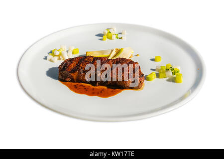 Arrosto di manzo rosso filetto di carne con ketchup sulla piastra bianca isolata su sfondo bianco Foto Stock