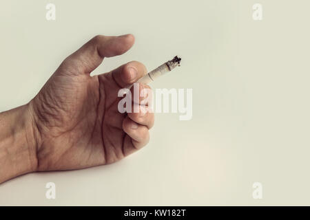 Studio shoot della mano che tiene una sigaretta sullo sfondo bianco Foto Stock
