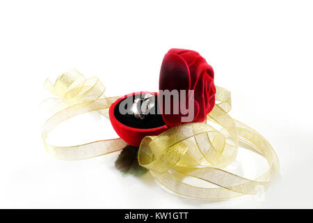 Nozze anello di argento in un fiore rosso Scatola decorata con nastro color oro. Foto Stock