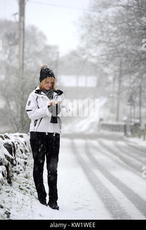 Affetside, Bury. 29 Dic, 2017. Regno Unito Meteo: un paese delle meraviglie invernali in scena come la neve copre il terreno attorno a Jumbles Country Park in Bolton, Lancashire. Una donna smette di rispondere il suo telefono. Foto di credito: Paolo Heyes/Alamy Live News Foto Stock