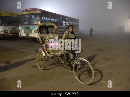 Di Allahabad, Uttar Pradesh, India. 29 Dic, 2017. Di Allahabad: un Indiano estrattore rikshaw attendere per i passeggeri durante un freddo e la nebbia notte in Allahabad. Credito: Prabhat Kumar Verma/ZUMA filo/Alamy Live News Foto Stock