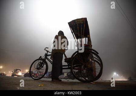 Di Allahabad, Uttar Pradesh, India. 29 Dic, 2017. Di Allahabad: un Indiano Rikshawmen attendere per i passeggeri durante un freddo e la nebbia notte in Allahabad. Credito: Prabhat Kumar Verma/ZUMA filo/Alamy Live News Foto Stock