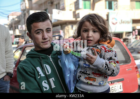 La Giordania. 30 Dic, 2017. Un ragazzo e una ragazza stand al di fuori di un rifugiato siriano centro in Mafraq, vicino al confine Syrian-Jordanian. Le aree la popolazione è ora la metà dei rifugiati.Attualmente ci sono oltre 700.000 profughi siriano in Giordania in fuga dal conflitto in casa nazione che ha iniziato a partire dal 2011. Credito: Sally Hayden/SOPA/ZUMA filo/Alamy Live News Foto Stock