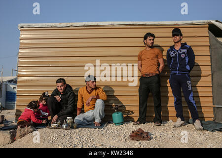 La Giordania. Xxi gen, 2017. Uomini e bambini attendere da un rifugio in Zaatari Refugee Camp, il più grande campo per rifugiati siriano, che ha aperto nel 2012. Si sta gradualmente trasformando in un insediamento permanente.Attualmente ci sono oltre 700.000 profughi siriano in Giordania in fuga dal conflitto in casa nazione che ha iniziato a partire dal 2011. Credito: Sally Hayden/SOPA/ZUMA filo/Alamy Live News Foto Stock