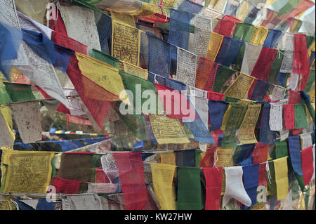 Luminose differenti colori sfondo dalla preghiera buddista bandiere con i mantra in sanscrito. Foto Stock