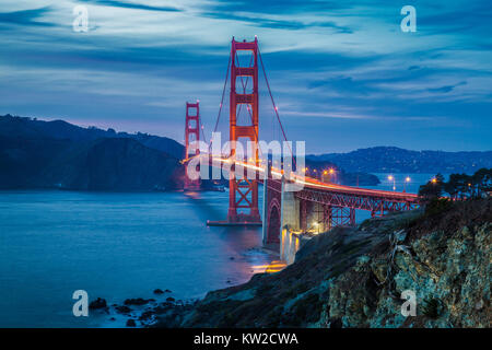 Classic vista panoramica del famoso Golden Gate Bridge visto da scenic Baker Beach in splendida post tramonto tramonto con cielo blu e nuvole al tramonto in Foto Stock