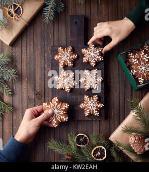 Uomo e donna che mantiene il Natale gingerbread stelle sul rustico sfondo di legno Foto Stock