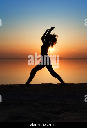 La ragazza è la pratica dello yoga su una costa di un golfo. Foto Stock