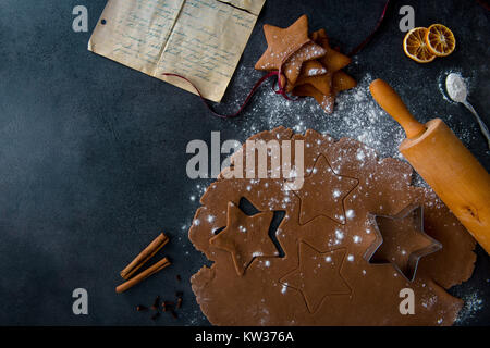 Natale stella di panpepato cookie cutter sul pan di zenzero pasta con esclusione dei cookie, cotta gingerbread cookie e antica ricetta di cucchiaino di farina. Foto Stock