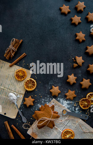 Vista superiore della preparazione di alimenti. A forma di stella gingerbread cookie disposti in forma di shooting star e ingredienti. Scena disordinato. Foto Stock
