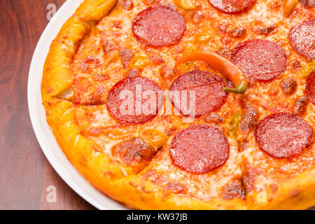 Close up di piccante pizza su una tavola di legno Foto Stock