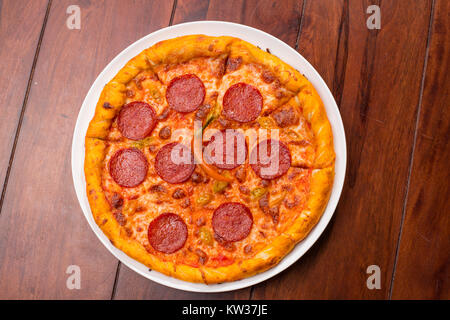 Close up di piccante pizza su una tavola di legno Foto Stock