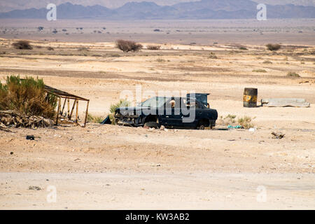 Rotture di blu scuro auto senza ruote si erge nel deserto Arava Foto Stock