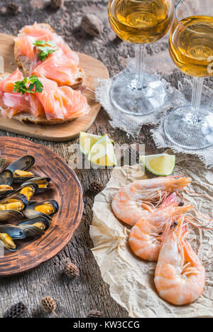 Frutti di mare con due bicchieri di vino bianco sul tavolo di legno Foto Stock