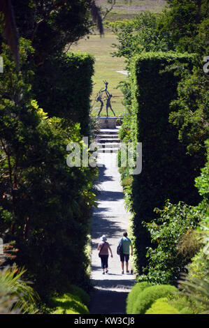 Un paio sul faro passeggiata che conduce alla scultura di tre Tresco bambini che giocano in Abbey Gardens, Tresco, isole Scilly, Cornwall, Regno Unito Foto Stock