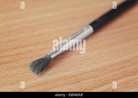 Vista ingrandita del vecchio e usate un pennello su un tavolo di legno. Foto Stock