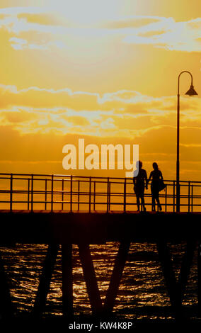 Giovane camminando sul molo di Glenelg in spiaggia Foto Stock