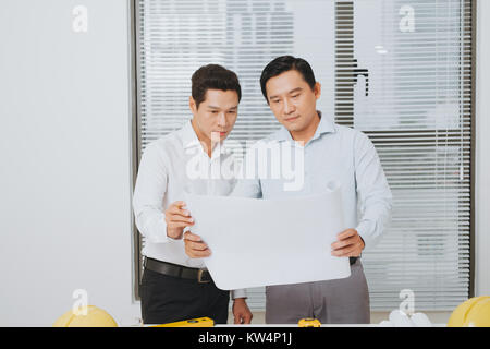 I colleghi maschi discutere le idee circa il progetto in ufficio, un concetto architettonico Foto Stock