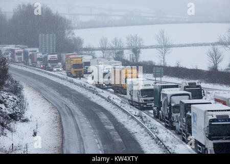 Autocarri e vetture che hanno bloccato sulla A14 vicino a Desborough,Northants, per otto ore a Mercoledì 27 dicembre dopo una notte di neve ha causato numerosi crash e chiuso la strada. Forze di polizia sono i driver di segnalazione di condizioni di pericolo sulle strade dopo la neve è scesa in parti del Regno Unito per tutta la notte. La M1 è stata bloccata al junction 19 dopo un incidente di camion, mentre la polizia ha detto che vi era stato 'multiple collisioni' sulla A14 nel Northamptonshire. Il Met Office ha rilasciato le avvertenze per il ghiaccio per il nord della Scozia, Irlanda del Nord e del nord-est dell'Inghilterra e neve per il Galles e parti dell'Inghilterra. Foto Stock