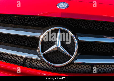 Logo Mercedes Benz su una griglia per auto rossa. Mercedes-Benz è un'azienda automobilistica tedesca. Il marchio è utilizzato per automobili di lusso, autobus, pullman Foto Stock