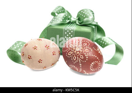 Decorate le uova di Pasqua e scatola regalo decorata con nastro su sfondo bianco Foto Stock